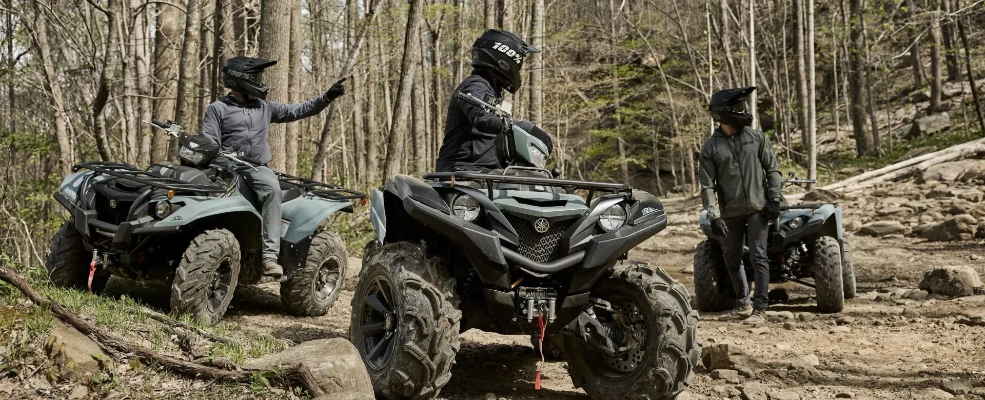 Three riders on Yamaha ATVs exploring a wooded trail at Karl Malone Powersports Provo
